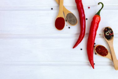 Kırmızı kırmızı biber ve biber karışımı beyaz ahşap arka planda.