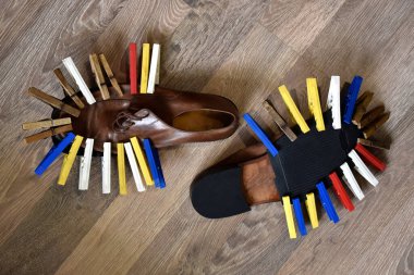 Shoes glued sole sandwiched with colorful clothespins clipart