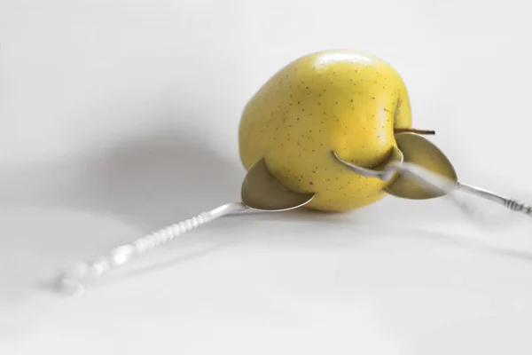 黄色のリンゴと3つの銀のティースプーンがさまざまな角度で詰め込まれています — ストック写真