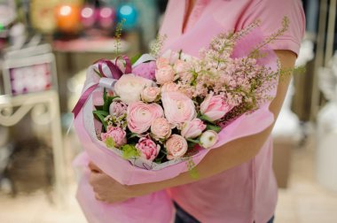 Düğünçiçeği, peonies ve diğer güzel çiçekler bir çiçek dükkanında oluşan bir ihale pembe çiçek kompozisyon tutan çiçekçi