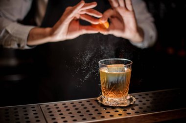Profesyonel barmen çubuğu'nda taze alkollü kokteyl içmek için bir portakal lezzet suyu ekleyerek sayaç