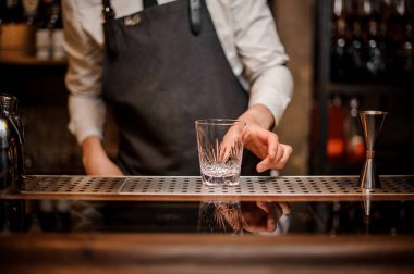 Bara bir güzel oranate cam koyarak barmen counter bulanık backgroung üzerinde taze yaz kokteyl hazırlamak için bar