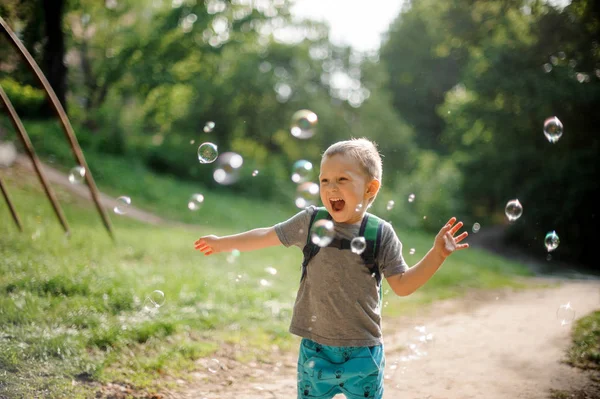 Happy Tertawa Anak Kecil Dengan Ransel Bermain Dengan Gelembung Sabun — Stok Foto