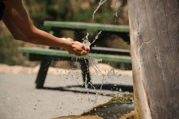 Spruzzi d'acqua nelle mani delle ragazze nella zona rurale — Foto Stock