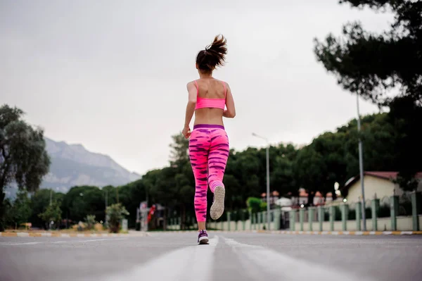 Achteraanzicht Van Jonge Vrouw Gekleed Roze Sportkleding Loopt Langs Snelweg — Stockfoto