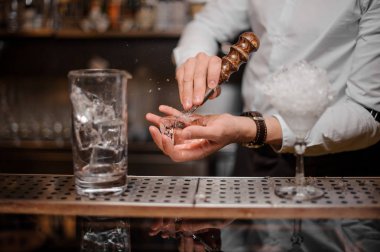Profesyonel barmen bir buz küpü bir kokteyl için özel araç ile çelik kırma bar counter