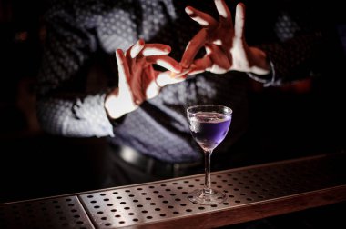 Güçlü içine portakal suyu ve taze mor yaz kokteyl koyu arka plan üzerinde tutam barmen