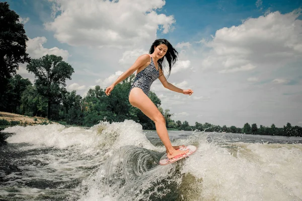Genç güzel kadın wakeboard Motorbot gölde yüksek dalga sürme