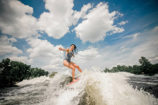 Genç güzel kadın wakeboard Motorbot gölde yüksek dalga sürme