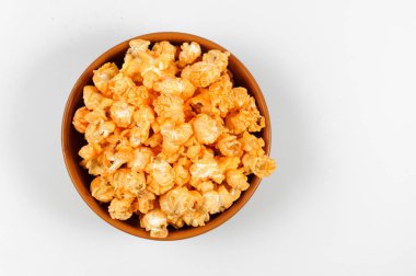 Beyaz arka plan üzerinde izole kahverengi kase lezzetli tuzlu altın patlamış mısır kısmı yukarıda görüntülemek