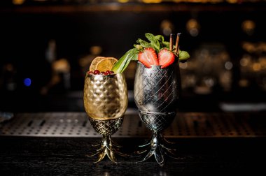 İki kokteyller ananas su bardağı çilek ve nane ve çilek ve turuncu çubuğunda formu sayaç