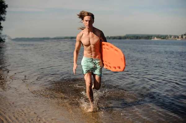 Nehir kıyısında yaz gününde hayat kurtaran ekipman ile birlikte çalışan çekici seksi uzun saçlı plaj cankurtaran