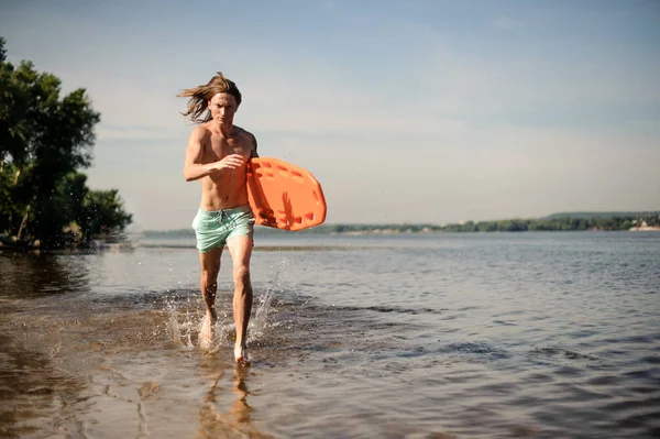 Jonge Sexy Langharige Strand Badmeester Lopen Water Met Levensreddende Apparatuur — Stockfoto