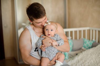 Onların üzerinde arka plan bulanık tatlı ev genç esmer baba küçük mavi gözlü sarışın kızı tutan eller