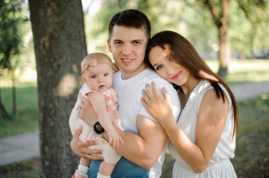 Küçük sarışın kızları arka plan bulanık genel parkta ellerinde tutan mutlu anne