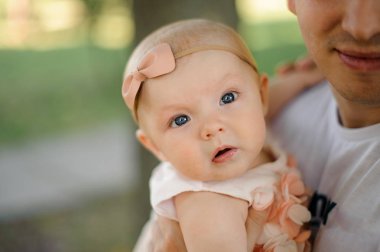 Genel arka plan bulanık parkta genç esmer baba küçük kızı tutan eller