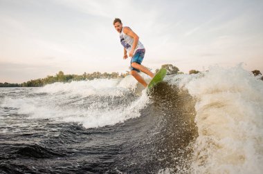 Active wakesurfer nehir dalgaları arka planı aşağı sürme gemide atlama açık gökyüzü