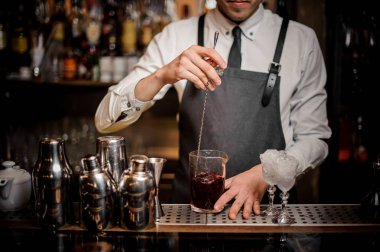 Cam çubuğu'nda bir taze ve lezzetli yaz alkollü kokteyl karıştırarak barmen sayaç