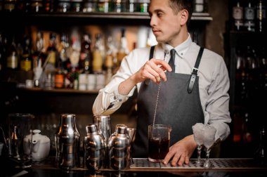 Genç barmen bir taze ve lezzetli yaz alkollü kokteyl çubuğu'nda cam karıştırma sayaç