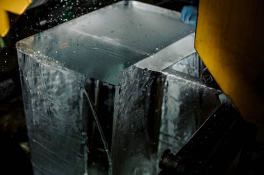 Adam özel bir makine araç ile büyük açık buz küp buz üretim tesisi karanlıkta kesim