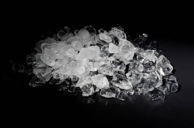 Düşen küçük beyaz ve şeffaf buz küpleri yığını izole siyah arka plan üzerine