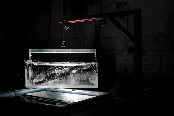 つのスポット ライトで暗闇の中で氷の生産工場に特殊ホルダーで大きなアイス キューブ — ストック写真