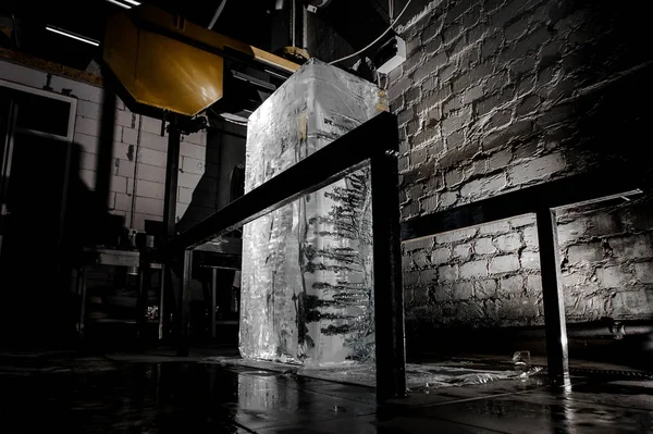 別のコンピューター機器の壁の背景に つのスポット ライトで暗闇の中で氷の工場床に大きなクリア アイス キューブ立って — ストック写真