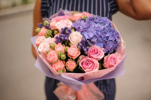 그녀의 분홍색 장미와 바이올렛 종이에 꽃다발을 어두운 드레스 — 스톡 사진