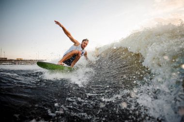 Sağlıklı yaz sahip wakeboard motorbot, yüksek dalga bükülmüş ayak üzerinde sürme genç çekici etkin adam