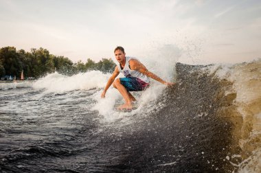 Sağlıklı yaz aylarında açık havada olan genç etkin adam wakeboard motorbot, yüksek dalga sürme