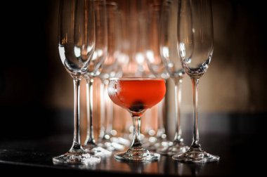 Arka plan bulanık çubuğunda taze lezzetli alkollü yaz kırmızı kokteyl ayakta arasında boş kokteyl şampanya bardakları