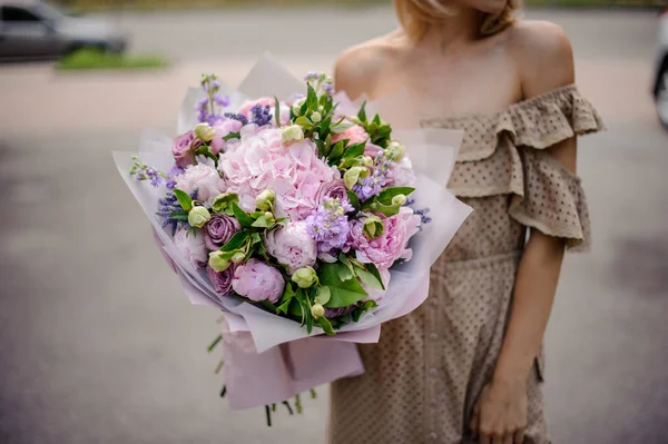 베이지색 드레스 그녀의 부드러운 분홍색과 보라색 꽃다발을 — 스톡 사진