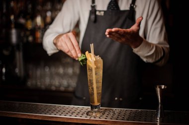 Barmen bir ekşi ve tatlı taze yaz kokteyl portakal dilimleri ve nane ile dekorasyon yapma