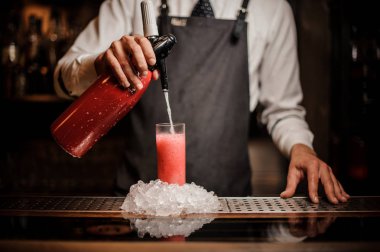 Alkollü köpüklü su ile tatlı kırmızı dut yaz kokteyl barda bir bardak içine dökme barmen sayaç