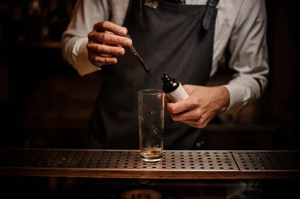 Barman Aggiungendo Amaro Marrone Bicchiere Cocktail Vuoto Con Pipetta Sul — Foto Stock