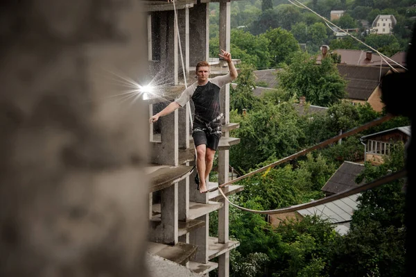 Onverschrokken Jongeman Balanceren Een Slackline Zomerdag Tegen Achtergrond Van Stad — Stockfoto