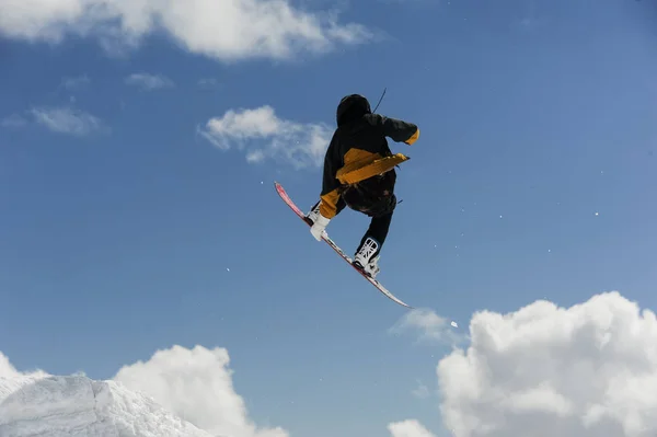 Atleta Masculino Casaco Amarelo Pulando Com Snowboard Alto Contra Céu — Fotografia de Stock