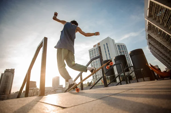 Jovem Homem Ativo Pulando Skate Contra Fundo Dos Edifícios Cidade — Fotografia de Stock