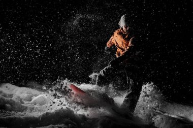 Genç adam snowboard dağ üzerinde kavak turizm tesisi Gudauri, Gürcistan'daki gece sürme.