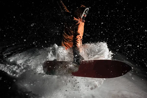 Man jumping with the snowboard in the mountain in the night in the poplar tourist resort in Gudauri, Georgia