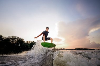 Wakeboard Motorbot bir göl arka plan üzerinde yüksek dalga yapma atlama genç çekici adam