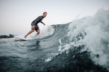 Etkin adam wakesurfing arka planı açık gökyüzü mavi su aşağı gemide