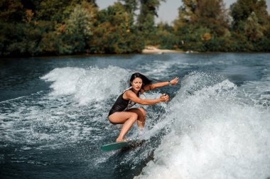 Esmer kadın wakesurfing güneşli mavi su aşağı kapalı gözlerle bir gemide