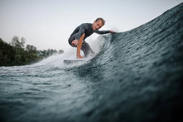 Wakeboarder Maiô Descendo Onda Azul Primeiro Plano Contra Céu Cinza — Fotografia de Stock