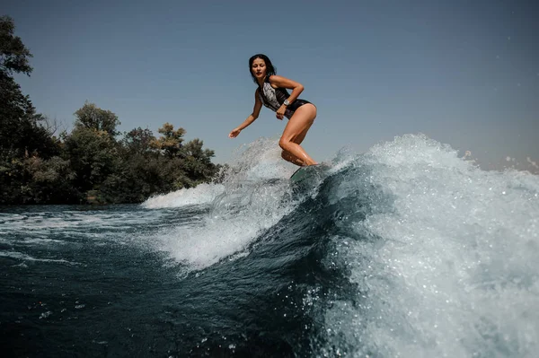 晴れた日に青い水をボード上のセクシーな若いブルネットの女性 Wakesurfing — ストック写真