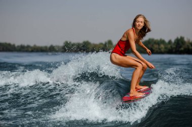 Bükme diz kırmızı wakeboard sürme kırmızı mayo dalgın güzel sarışın kız