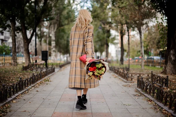 Вид Ззаду Блондинку Плетеному Пальто Йде Букетом Квітів Парку — стокове фото