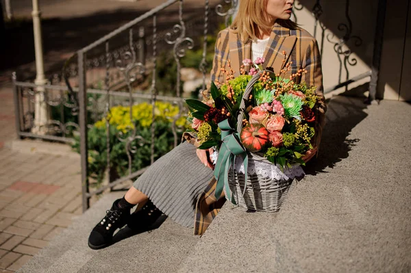 Wanita Bermantel Kotak Kotak Duduk Tangga Beton Dengan Keranjang Bunga — Stok Foto