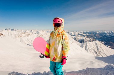 Parlak spor giyim ayakta Gürcistan, güneşli günde Gudauri dağ üstüne kadın snowboard