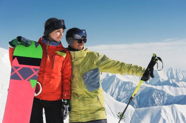 Kız snowboard ve kayakçı enjoing Dağlar bembeyaz toplayan ve Gudauri, Gürcistan'dan dağ tepe yüksekliği ormanları